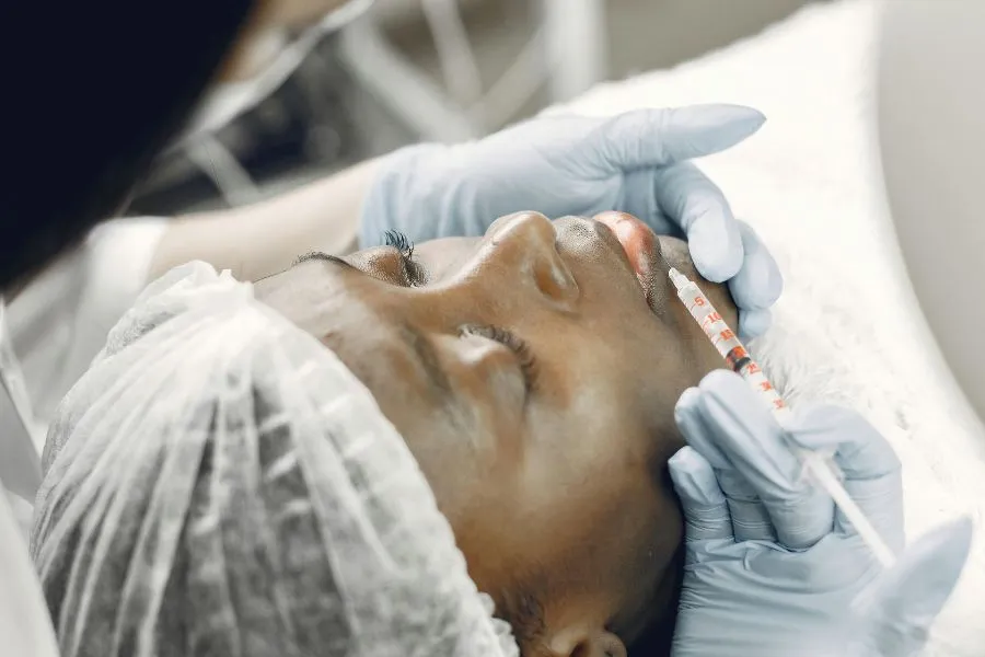 A girl getting an injection into her face.