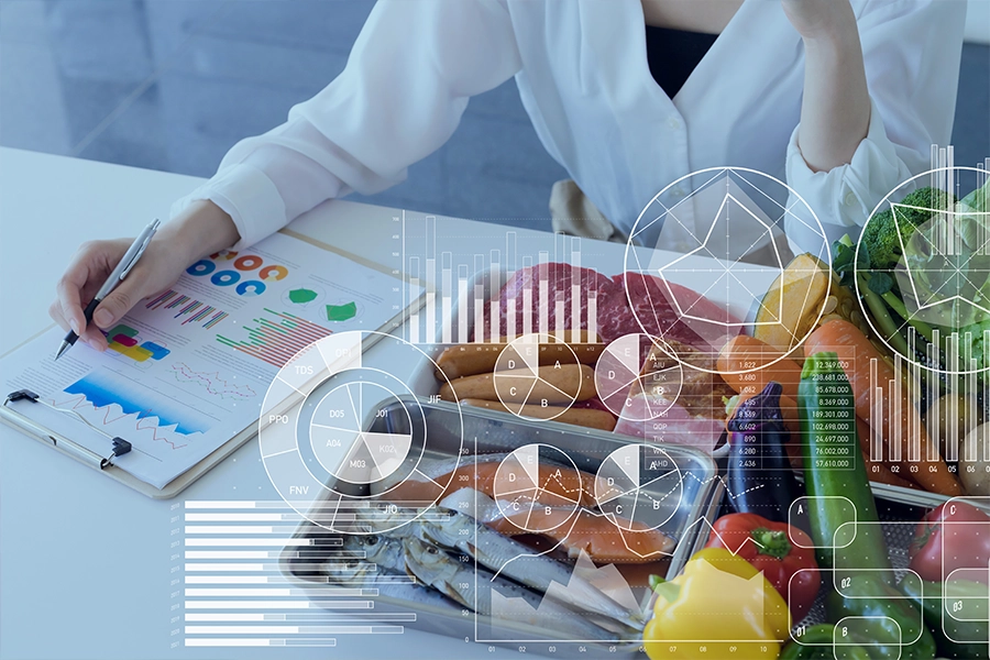 Άτομο με σημειωματάριο στο τραπέζι δίπλα σε κουτιά με λαχανικά και κρέας με διάφορα γραφήματα επικαλυμμένα