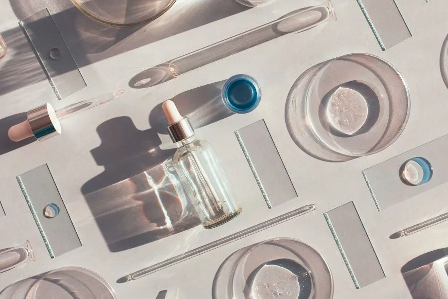 cosmetics ingredients on a white desk with lab equipment