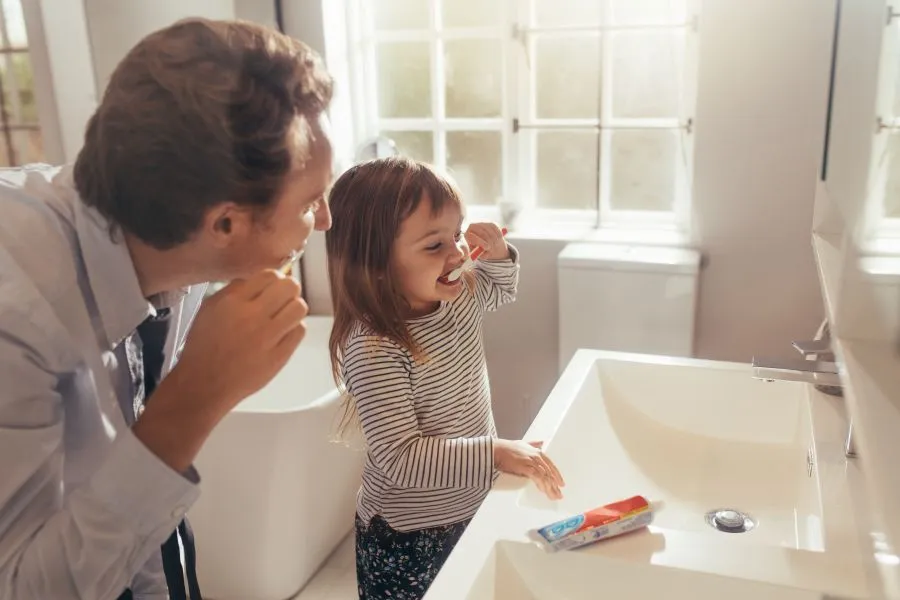 parent and child brushing teeth