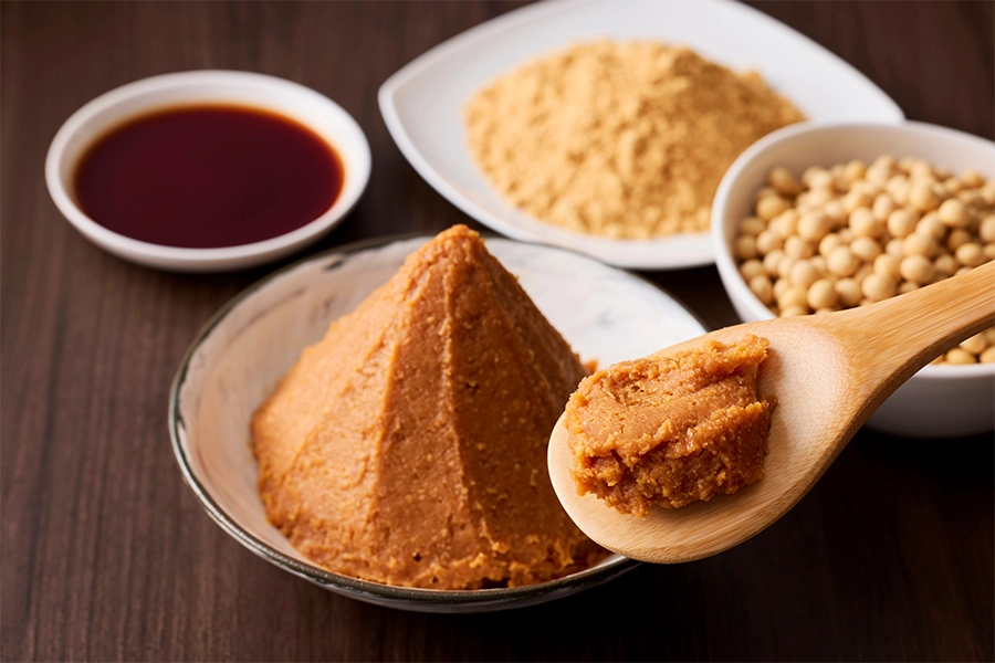 Miso paste and spoon on wooden table.