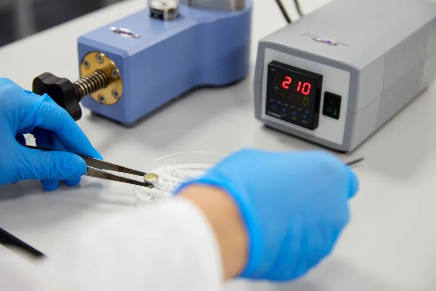 A person using a device to hold a piece of material