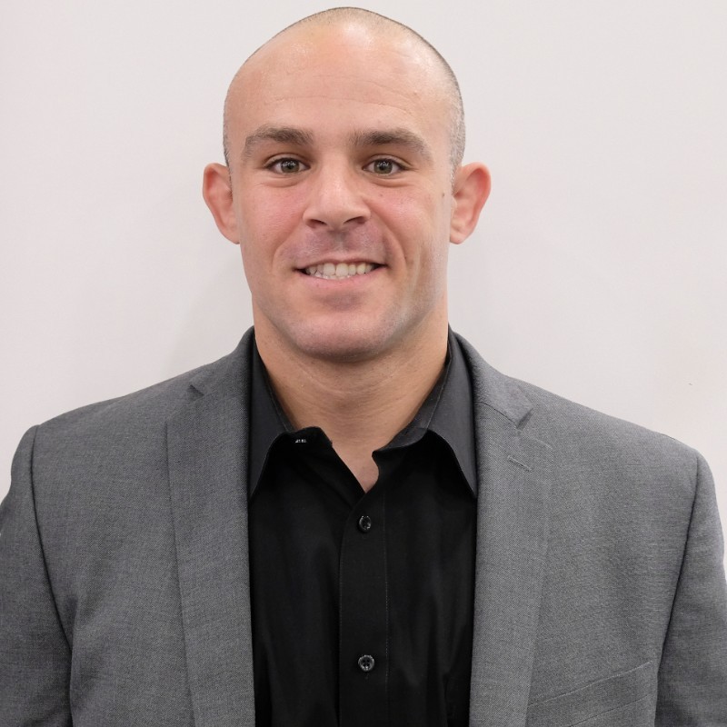 headshot of DuBow - bald in suit, smiling 