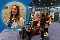 Image IFT First 2026 Almond Board of California video thumbnail: Representative pictured beside attendees gathering at the organization’s booth during a busy trade show.